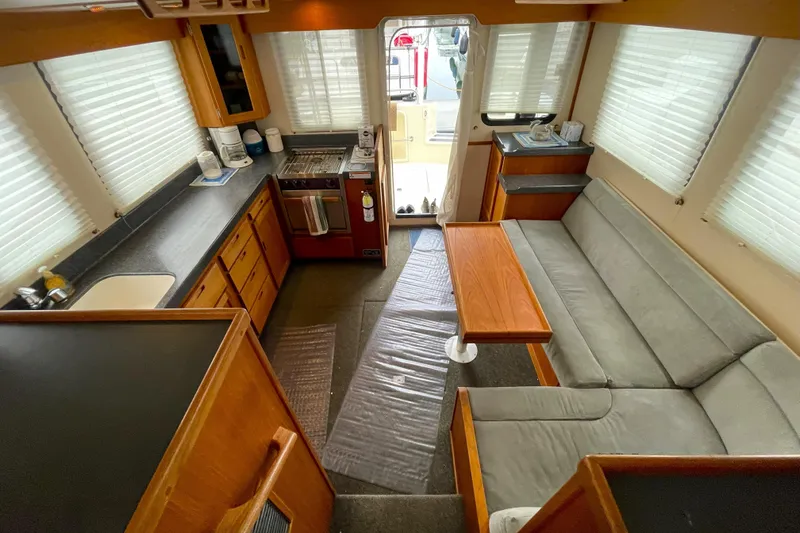 Lagnaf Yacht Photos Pics Interior of 2002 Nordic Tug 37, featuring kitchen and seating area with natural light.