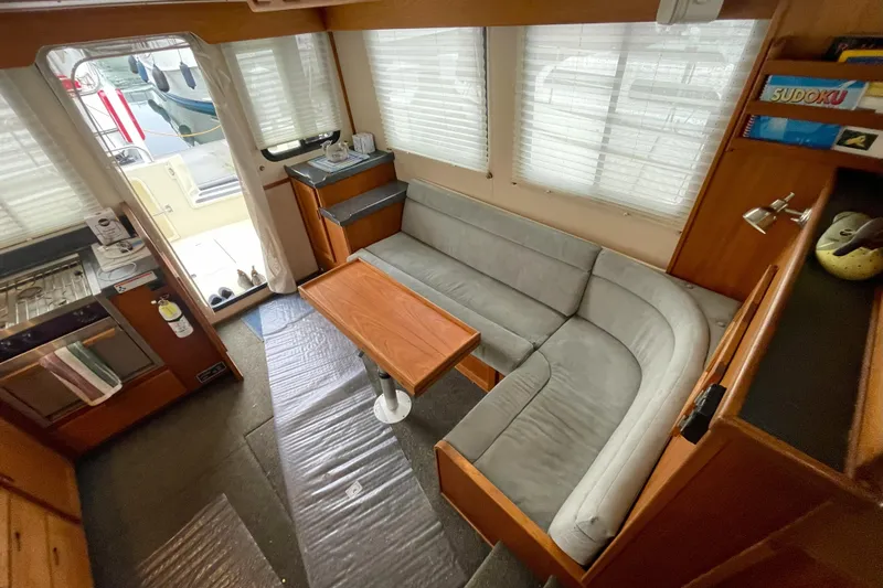 Lagnaf Yacht Photos Pics Interior of a 2002 Nordic Tug 37, featuring a cozy seating area and kitchenette.
