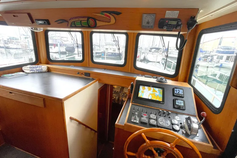 Lagnaf Yacht Photos Pics Interior of 2002 Nordic Tug 37 with navigation controls and marina view.