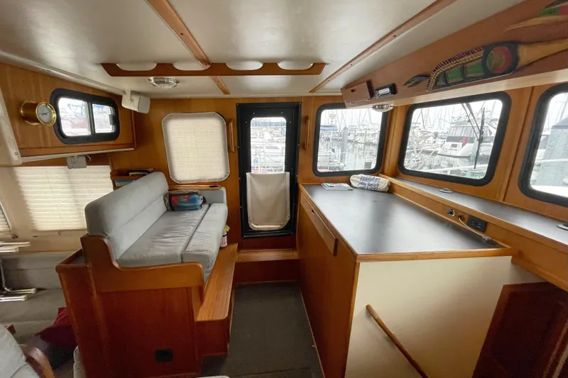 Lagnaf Yacht Photos Pics Cozy interior of a 2002 Nordic Tug 37 with seating and large windows.