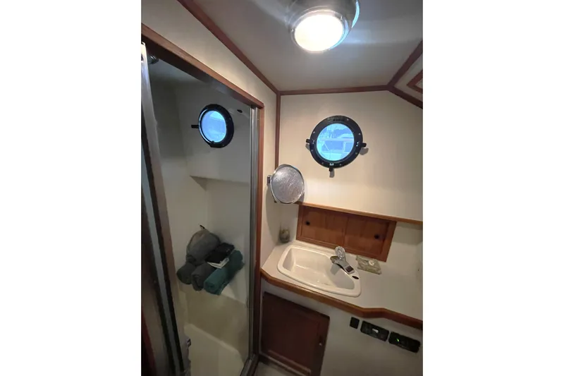 Lagnaf Yacht Photos Pics Bathroom interior of 2002 Nordic Tug 37 with porthole and sink.