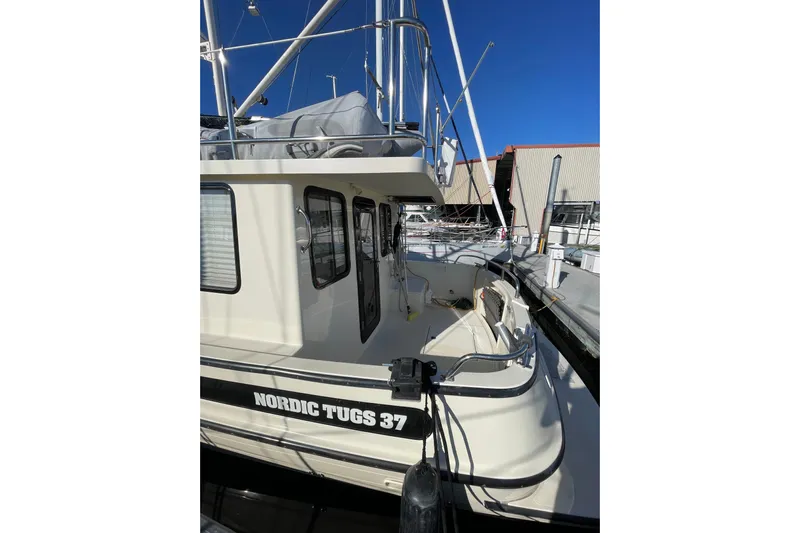 Lagnaf Yacht Photos Pics 2002 Nordic Tug 37 docked, showcasing exterior design and spacious deck area.