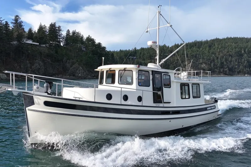 Lagnaf Yacht Photos Pics 2002 Nordic Tug 37 cruising on scenic water with forested shoreline.