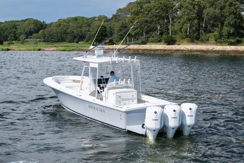 Distraction Yacht Photos Pics 2019 Regulator 34SS boat with triple engines cruising on a scenic waterway.