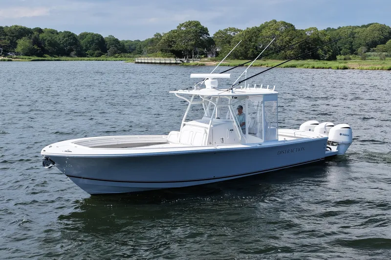 Distraction Yacht Photos Pics 2019 Regulator 34SS boat on water, featuring triple outboard engines and fishing rods.