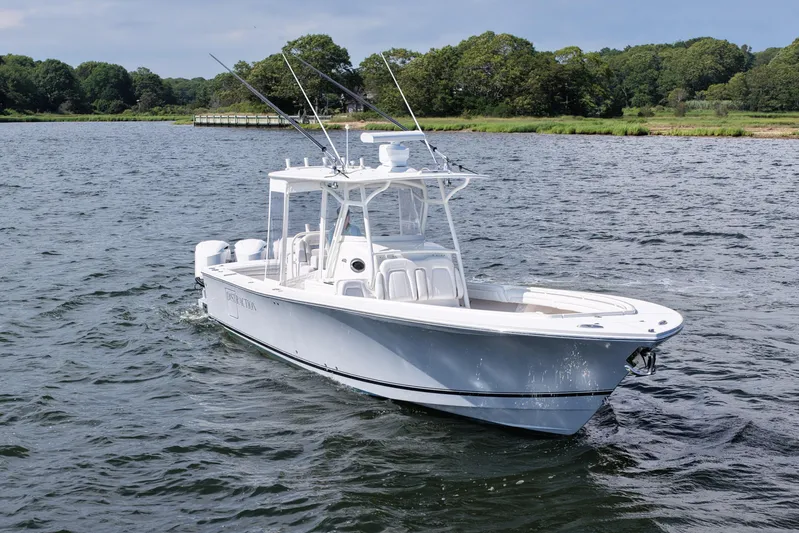 Distraction Yacht Photos Pics 2019 Regulator 34SS boat cruising on a scenic lake with lush green shoreline.