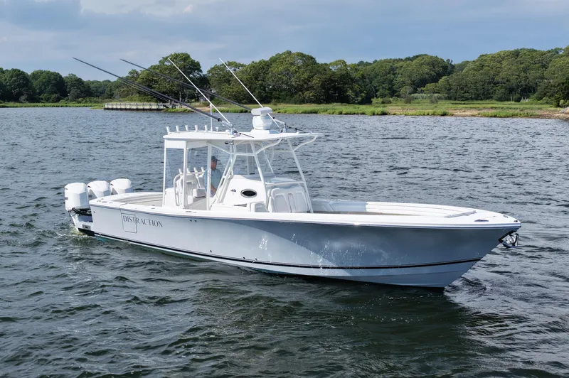 Distraction Yacht Photos Pics 2019 Regulator 34SS boat cruising on a scenic lake with lush green shoreline.