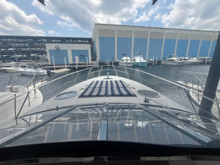  Yacht Photos Pics 2004 Regal Commodore 4260 yacht docked at marina with blue storage buildings.