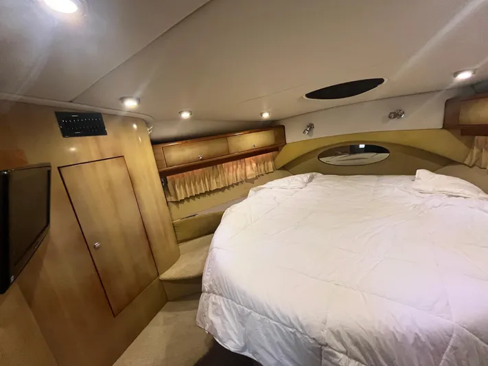  Yacht Photos Pics Luxurious bedroom interior of 2004 Regal Commodore 4260 yacht with cozy bedding and ambient lighting.
