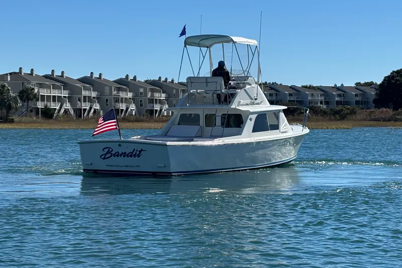 Bandit Yacht Photos Pics 1970 Bertram 31 Flybridge Cruiser "Bandit" on water near coastal homes.