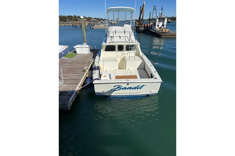 Bandit Yacht Photos Pics 1970 Bertram 31 Flybridge Cruiser docked, named "Bandit," in a marina setting.