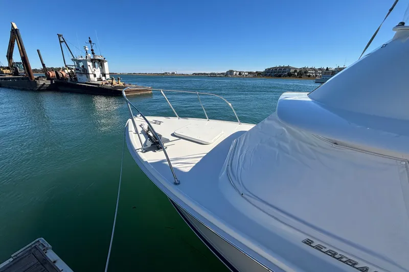 Bandit Yacht Photos Pics 1970 Bertram 31 Flybridge Cruiser docked in a serene marina setting.