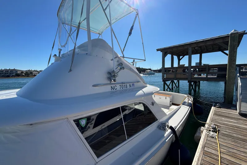 Bandit Yacht Photos Pics 1970 Bertram 31 Flybridge Cruiser docked at marina under clear blue sky.