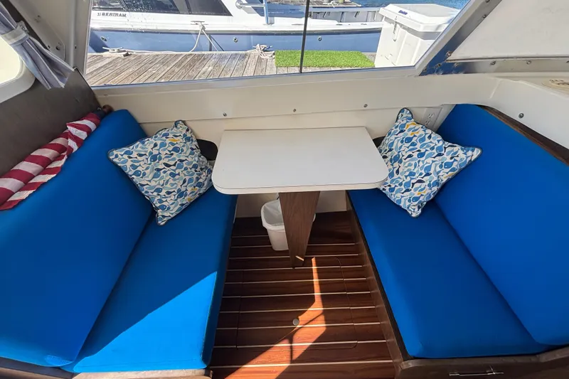 Bandit Yacht Photos Pics Interior of a 1970 Bertram 31 Flybridge Cruiser with blue seating and decorative pillows.