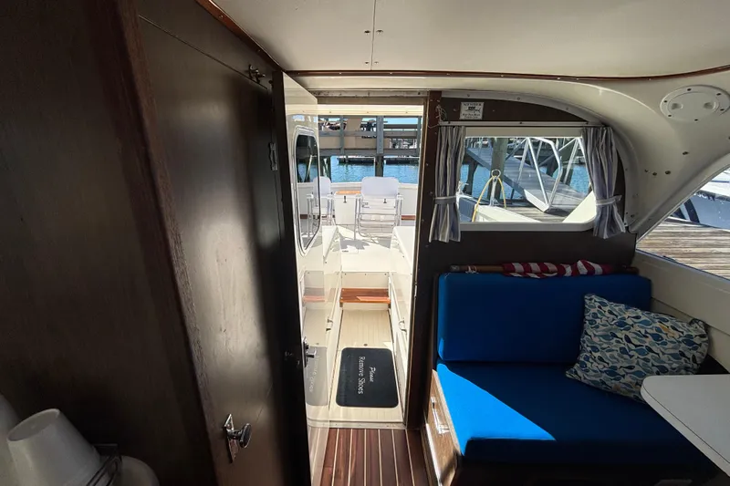 Bandit Yacht Photos Pics Interior view of 1970 Bertram 31 Flybridge Cruiser with blue seating and dockside view.