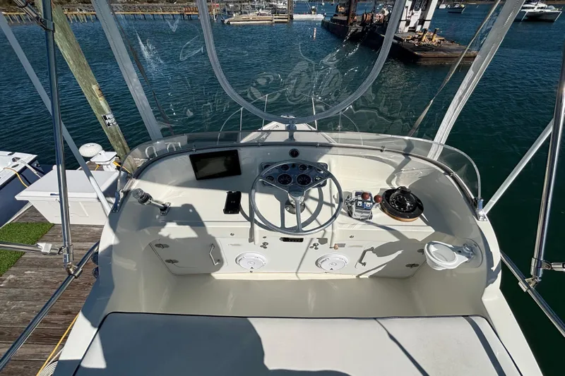 Bandit Yacht Photos Pics 1970 Bertram 31 Flybridge Cruiser helm with steering wheel, gauges, and navigation equipment.