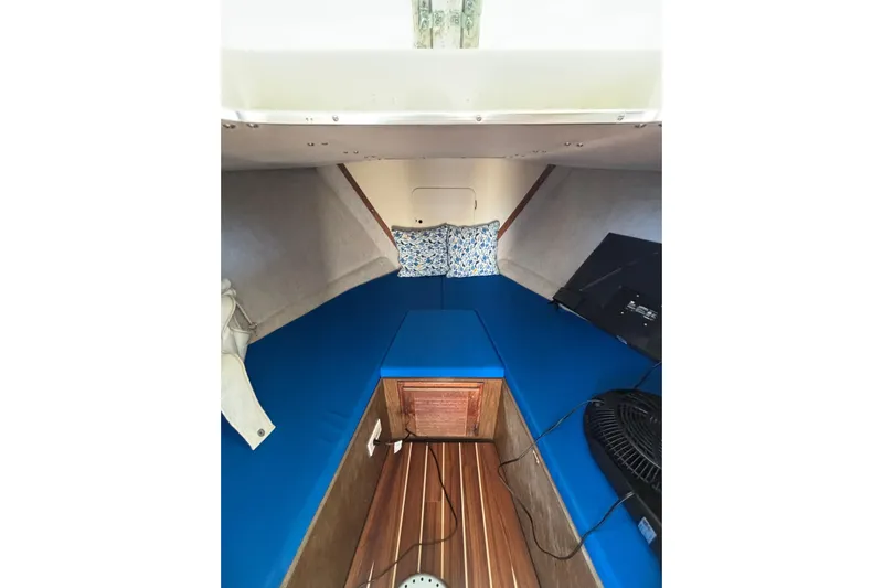 Bandit Yacht Photos Pics Interior of a 1970 Bertram 31 Flybridge Cruiser with blue cushions and wooden flooring.