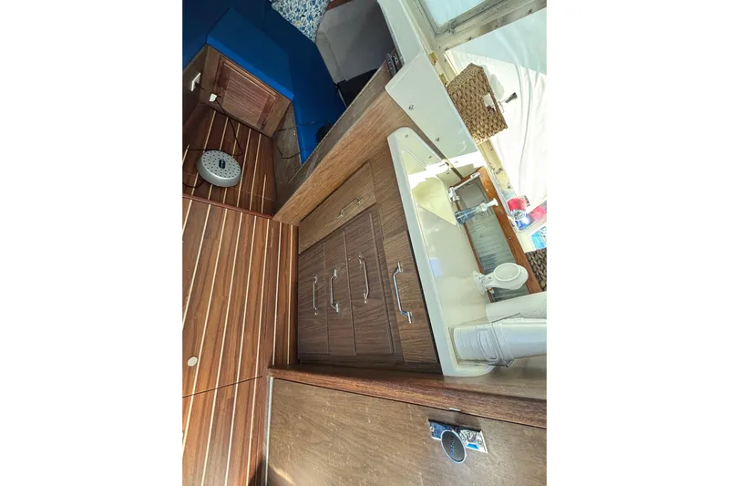 Bandit Yacht Photos Pics Interior of 1970 Bertram 31 Flybridge Cruiser with wood cabinetry and compact sink area.
