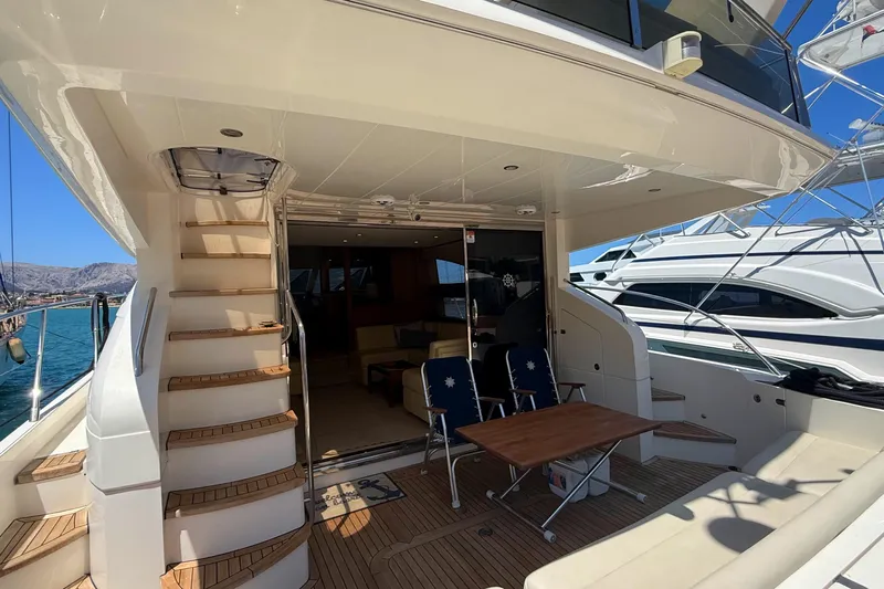  Yacht Photos Pics Luxurious 2010 Princess 62 yacht deck with seating and stairs, docked at marina.