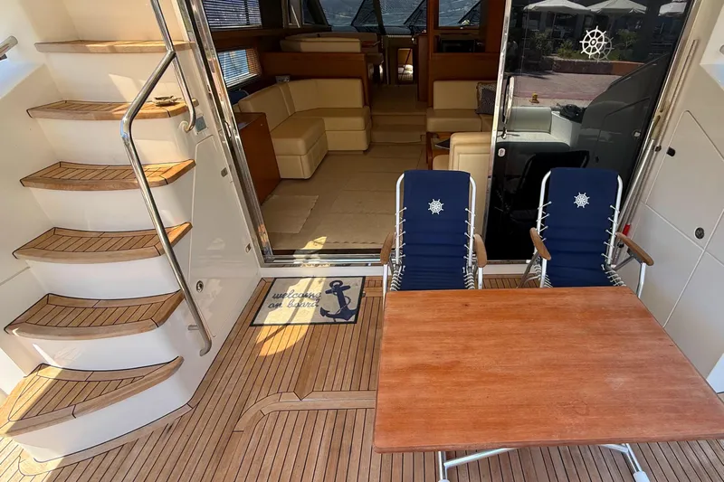  Yacht Photos Pics Luxurious 2010 Princess 62 yacht interior with wooden deck, chairs, and staircase.