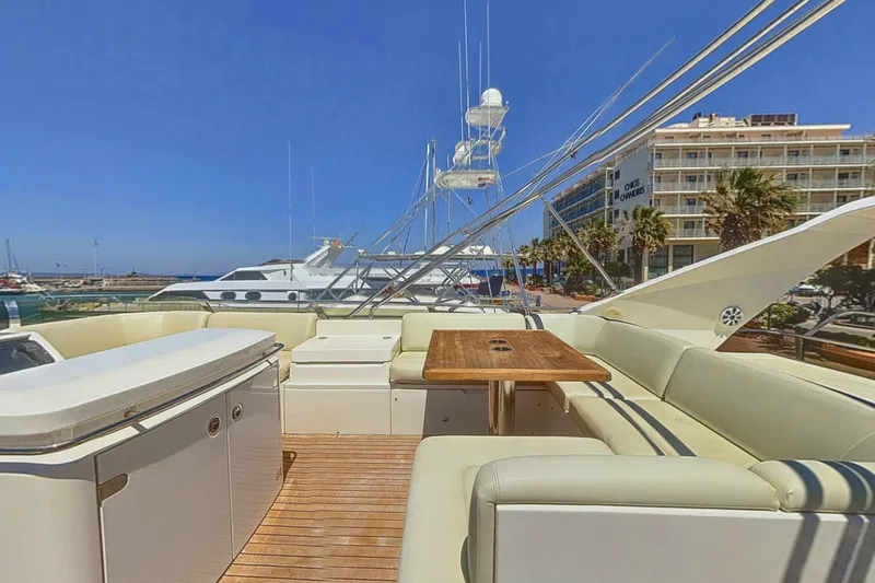  Yacht Photos Pics Luxurious 2010 Princess 62 yacht deck with seating and table, docked at a marina.