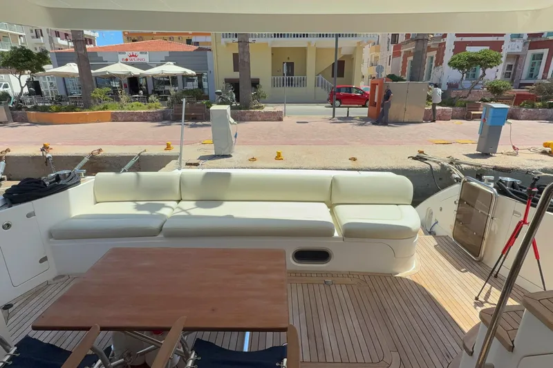  Yacht Photos Pics Luxurious 2010 Princess 62 yacht with spacious deck seating and wooden table, docked at marina.