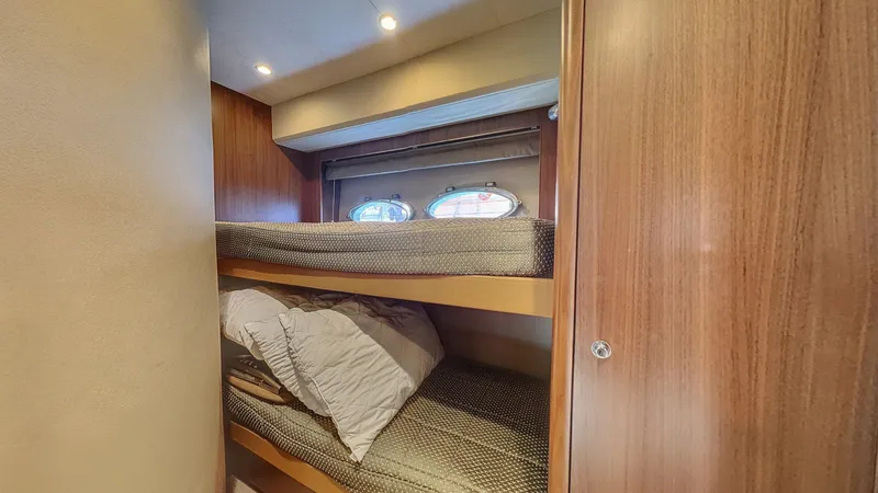  Yacht Photos Pics Bunk beds in 2010 Princess 62 yacht cabin with wooden interior and porthole windows.