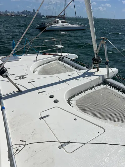 Taco Truck Yacht Photos Pics 1996 Prout 45 catamaran on water, featuring spacious deck and netting, with city skyline in background.