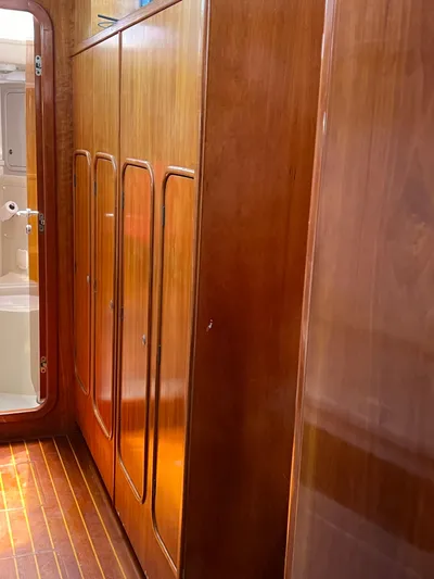 Taco Truck Yacht Photos Pics Wood-paneled interior of a 1996 Prout 45 yacht, featuring sleek cabinets and a bathroom door.