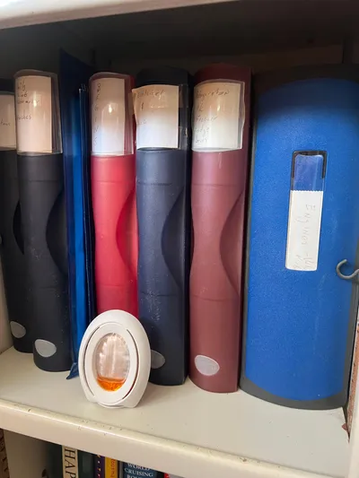 Taco Truck Yacht Photos Pics Shelf with assorted binders and a small decorative item, Prout 45, 1996.