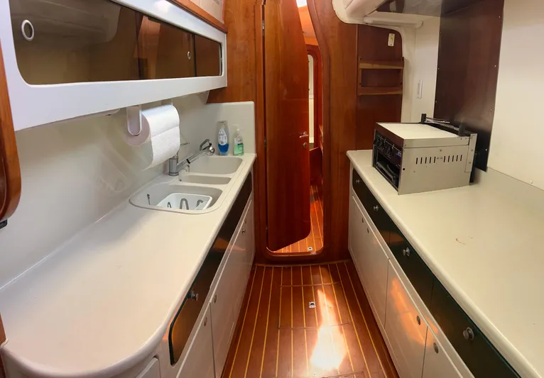 Taco Truck Yacht Photos Pics Galley kitchen in 1996 Prout 45 yacht with wood flooring and modern appliances.