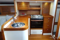 Luxurious yacht kitchen interior with wooden cabinetry, stainless steel sink, and modern stove, Von Ahlen 403, 2014.