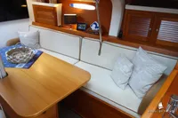 Cozy yacht interior with wooden table, cushioned seating, and decorative pillows, Von Ahlen 403, 2014.
