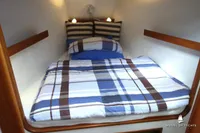 Cozy yacht cabin with striped bedding, wooden accents, and soft lighting, Von Ahlen 403, 2014.