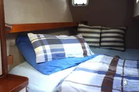 Cozy cabin bed with striped bedding in a 2014 Von Ahlen 403 yacht.
