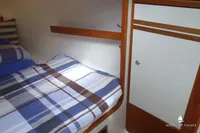Cozy cabin interior of 2014 Von Ahlen 403 yacht with striped bedding and wooden accents.