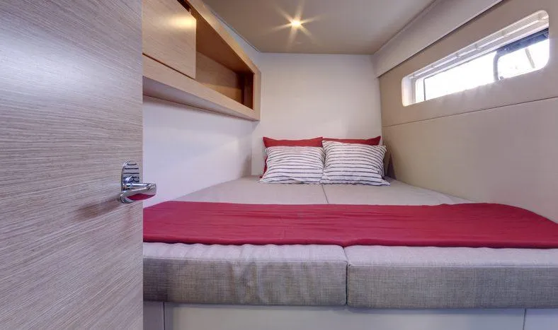 Escape Yacht Photos Pics Nautitech 40 Open 2016 model cabin with bed, striped pillows, and red blanket.