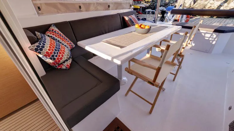 Escape Yacht Photos Pics Nautitech 40 Open 2016 yacht interior with dining area, cushioned seating, and decorative pillows.