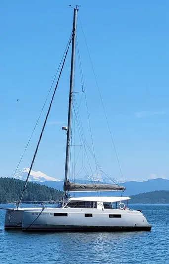 Escape Yacht Photos Pics 2016 Nautitech 40 Open catamaran sailing on a calm sea with scenic mountain backdrop.
