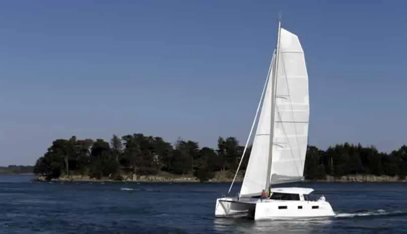 Escape Yacht Photos Pics Nautitech 40 Open 2016 catamaran sailing near a forested shoreline.