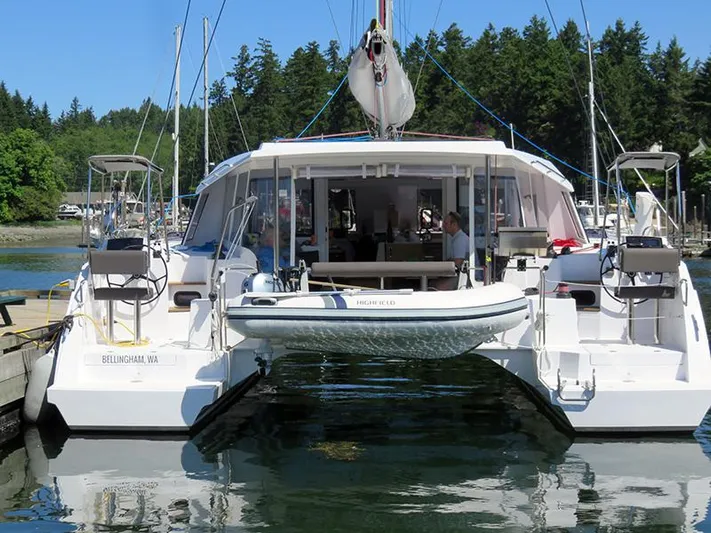 Escape Yacht Photos Pics 2016 Nautitech 40 Open catamaran docked in a marina with lush green trees in the background.