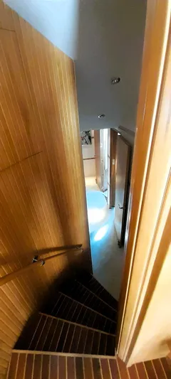  Yacht Photos Pics Staircase inside 2000 Hatteras 60 Convertible yacht, featuring wooden paneling and modern design.