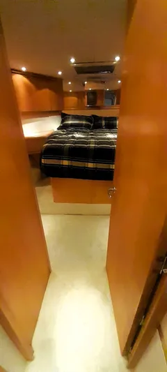  Yacht Photos Pics Interior cabin of 2000 Hatteras 60 Convertible yacht with cozy bed and wooden finish.