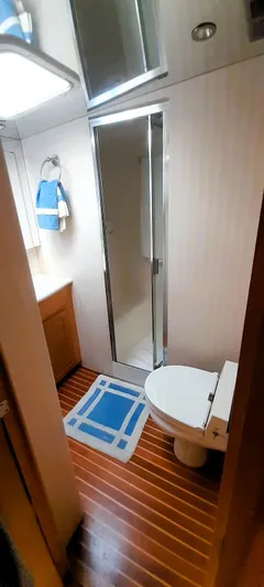  Yacht Photos Pics Bathroom interior of 2000 Hatteras 60 Convertible yacht with shower and wooden flooring.