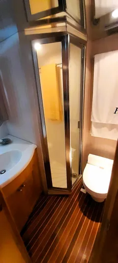  Yacht Photos Pics Bathroom interior of 2000 Hatteras 60 Convertible yacht with shower and wooden flooring.