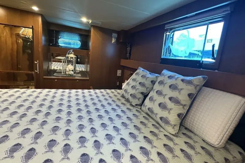 On Your Mark Yacht Photos Pics Luxurious 2005 Jefferson Motoryacht bedroom with fish-patterned bedding and elegant wood finishes.