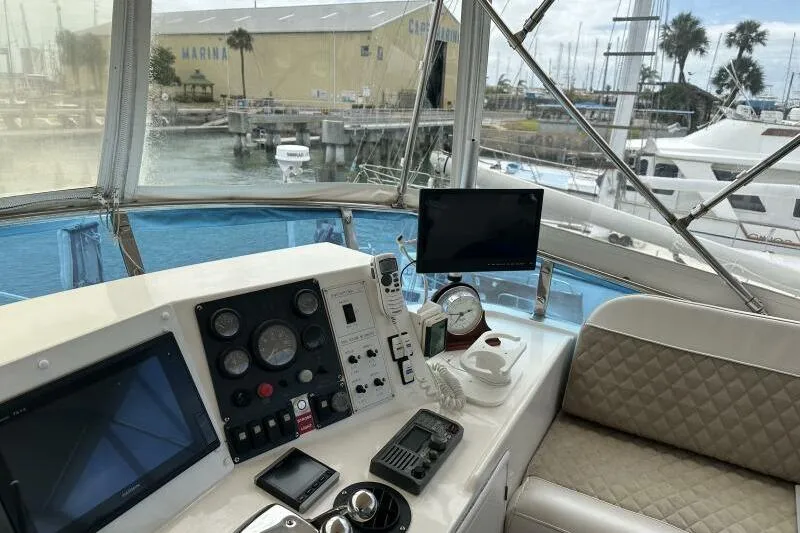 On Your Mark Yacht Photos Pics 2005 Jefferson Motoryacht helm with navigation equipment, marina view, and comfortable seating.
