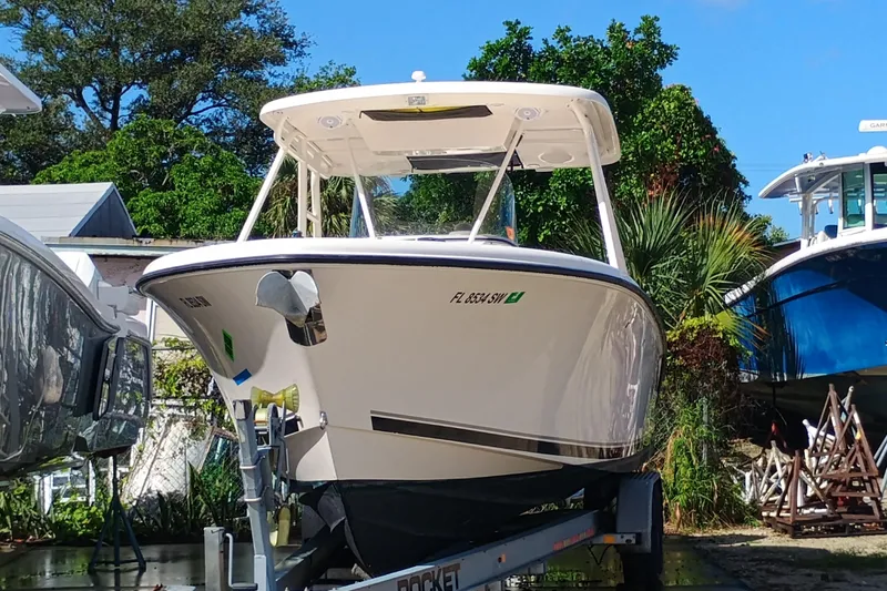S28-117 Brokerage Joe Yacht Photos Pics 2010 Pursuit S 280 Sport boat on trailer, surrounded by trees and other boats.