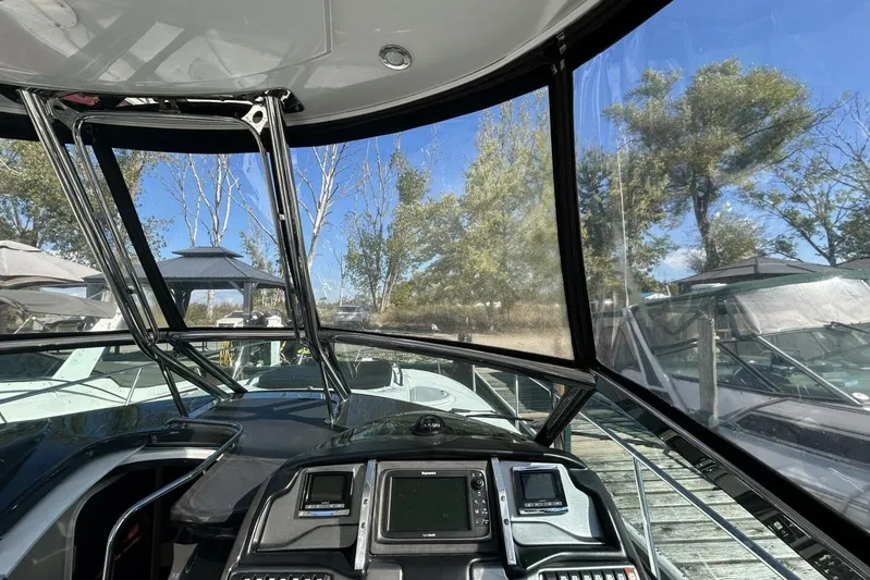  Yacht Photos Pics 2015 Monterey 355 Sport Yacht cockpit with clear canopy and control panel, docked outdoors.