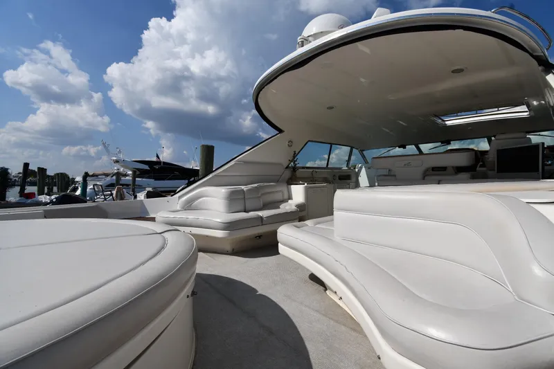  Yacht Photos Pics Luxurious 1995 Sea Ray 630 Sundancer yacht with spacious white seating under a blue sky.